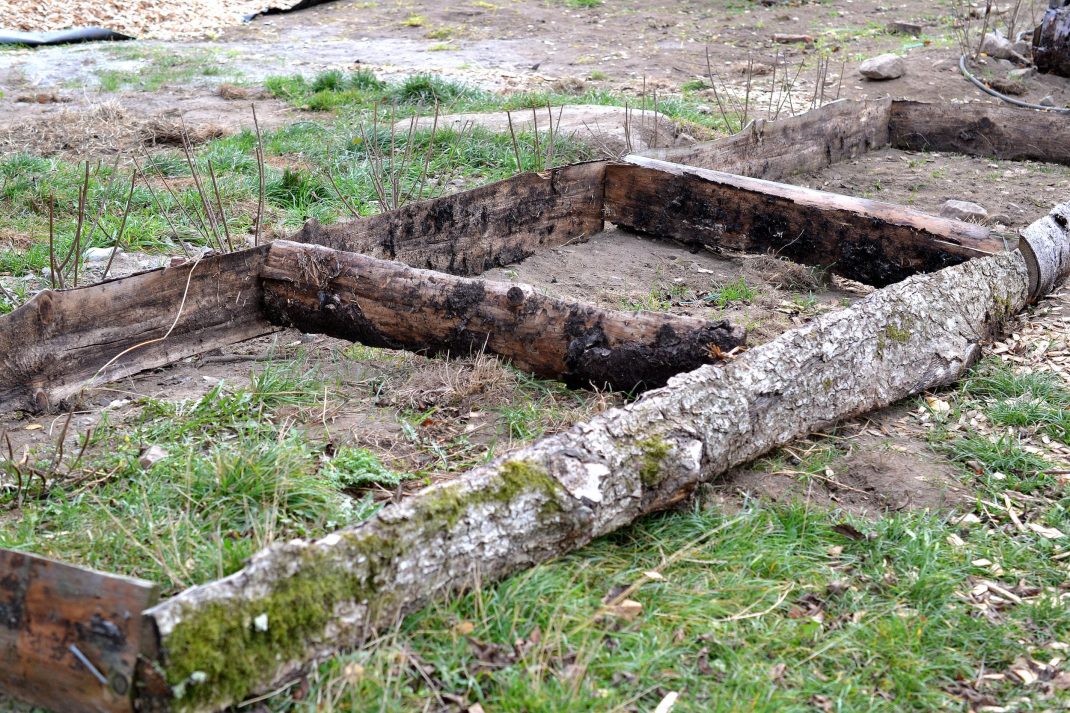 Odlingsram av ytved står på marken. Wooden frame on the ground. 