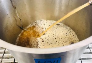 En kastrull med äppelmust och en termometersensor i.