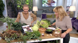 Sara och Malou von Siwerts står vid ett bord med massor av grönsaker på.