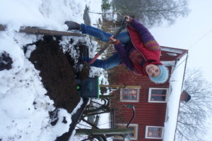 Sara gräver ner bokashi utomhus. Bredvid syns hinkar från bokashi.se.