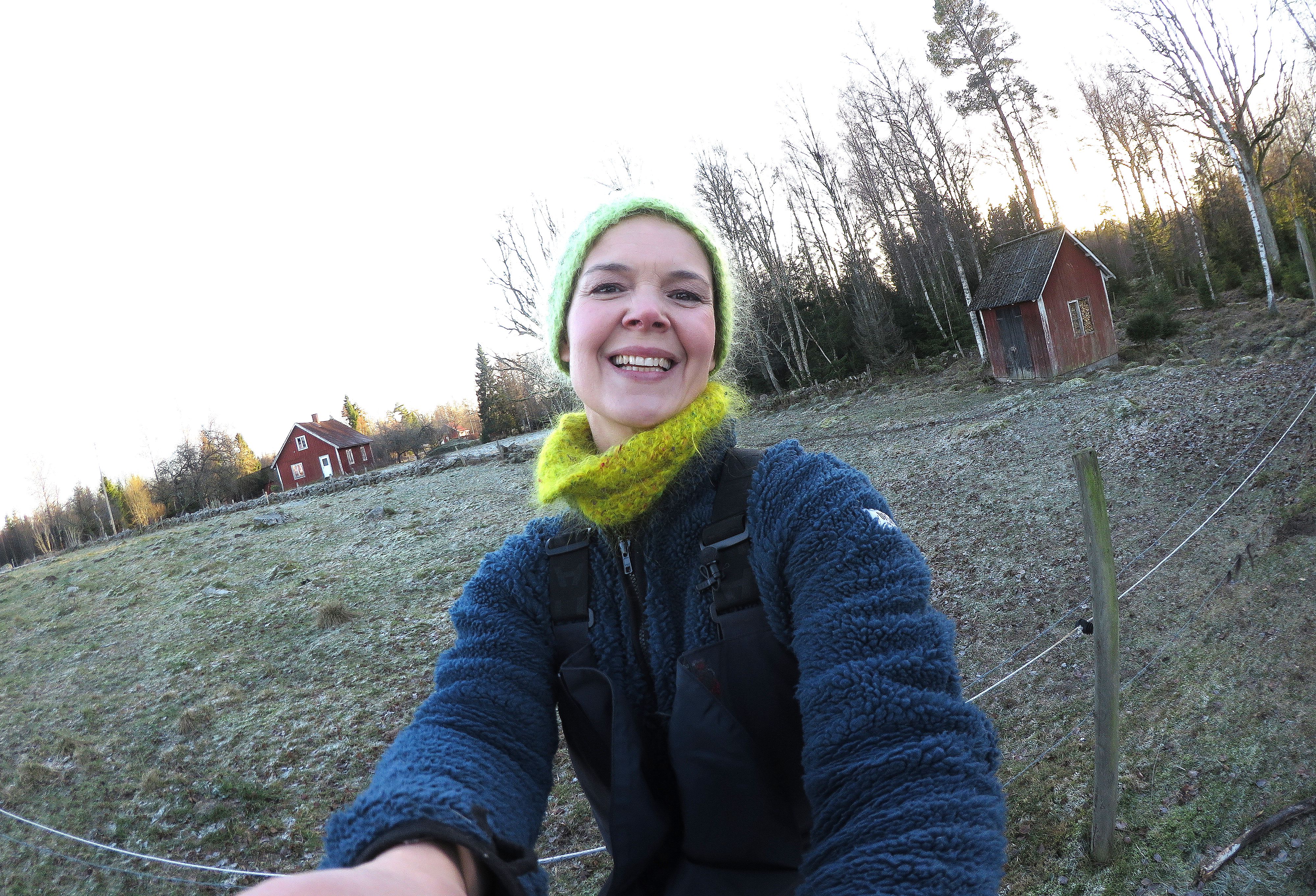 Sara Bäckmo står i trädgården med beteshagen bakom sig, vinter. #MyFavouriteVideo, Sara in the winter garden.
