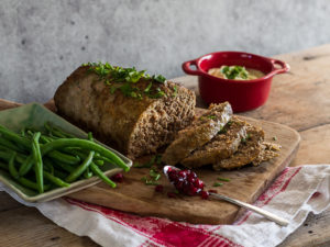 En fin köttfärslimpa ligger upplagd på ett fint träskärdbräde.