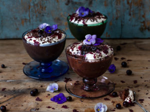 Vackra chokladpuddingar i små glad dekorerade med violer.
