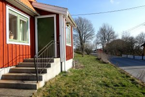 Ett rött hus alldeles vid vägen.