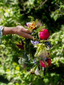 En hand håller en blomkrans
