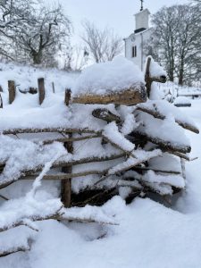 Snön har lagt sig på ett  kviststaket.