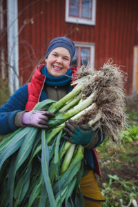 Sara med nyskördade purjolökar