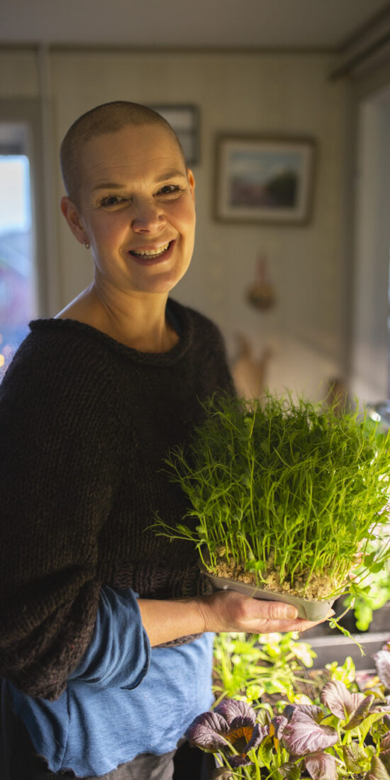 Sara with pea shoots in pots.