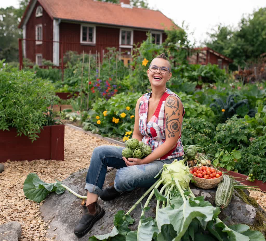 Sara Bäckmo mitt i en prunkande trädgård