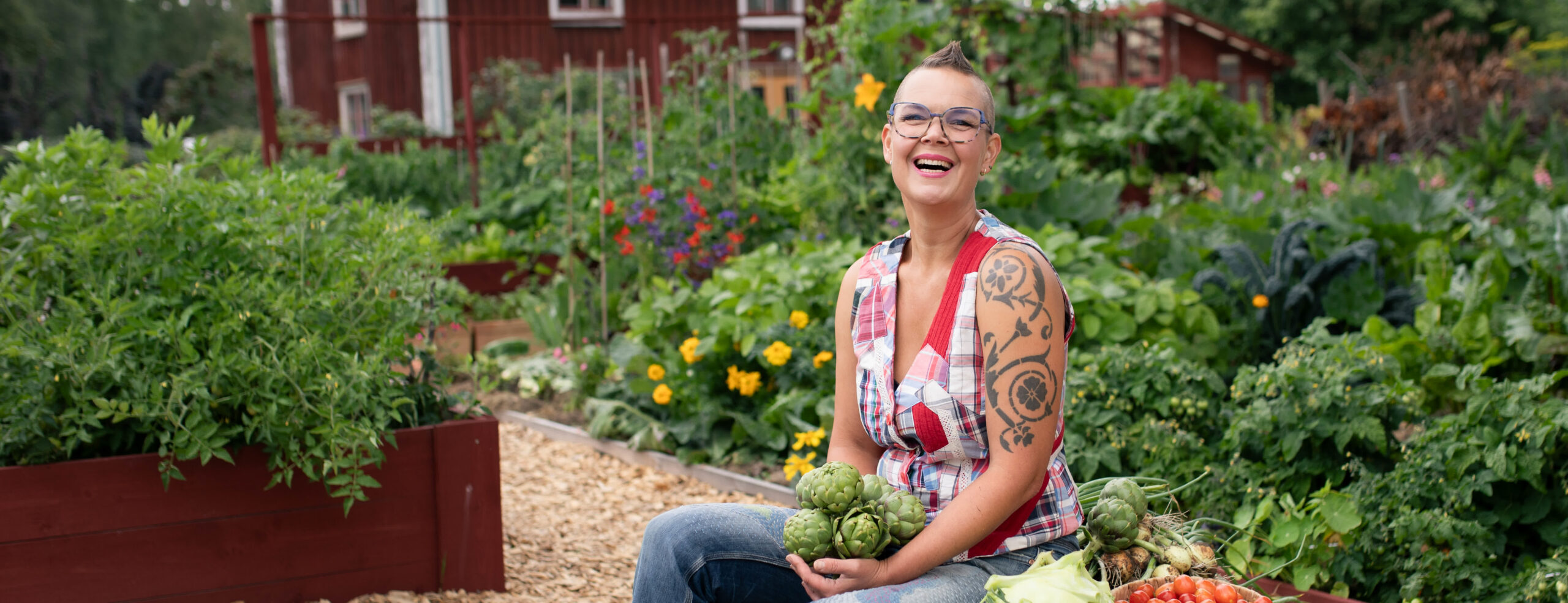 Sara Bäckmo mitt i en prunkande trädgård